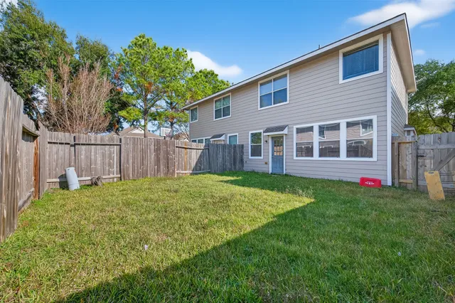 a view of a house with backyard and wooden fence