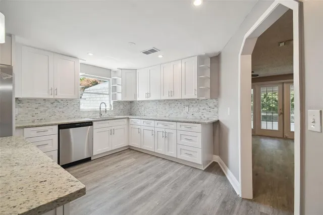 a kitchen with granite countertop a sink stove and cabinets