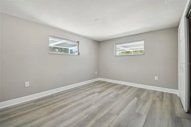 a view of empty room with wooden floor