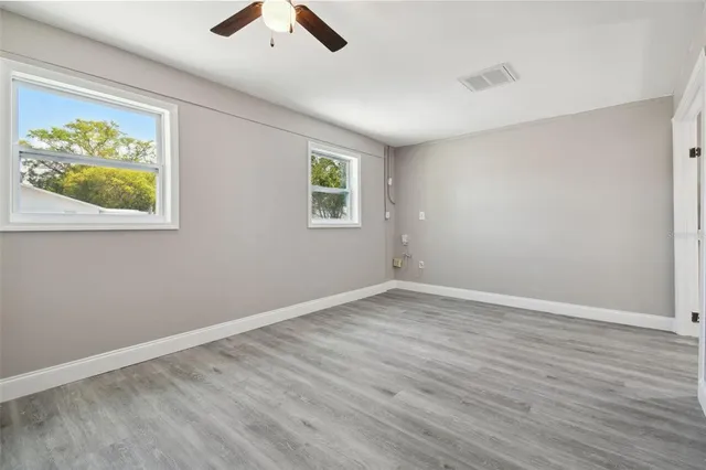 an empty room with wooden floor and window