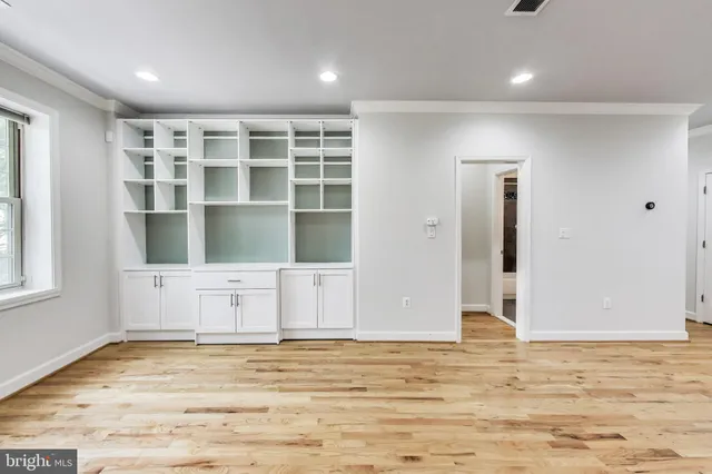 a view of an empty room with window and bathroom