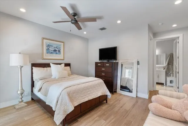 a spacious bedroom with a large bed and a wooden floor