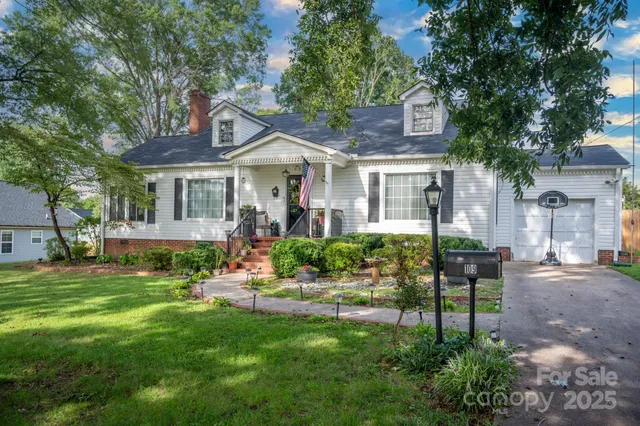 a front view of a house with a garden and plants
