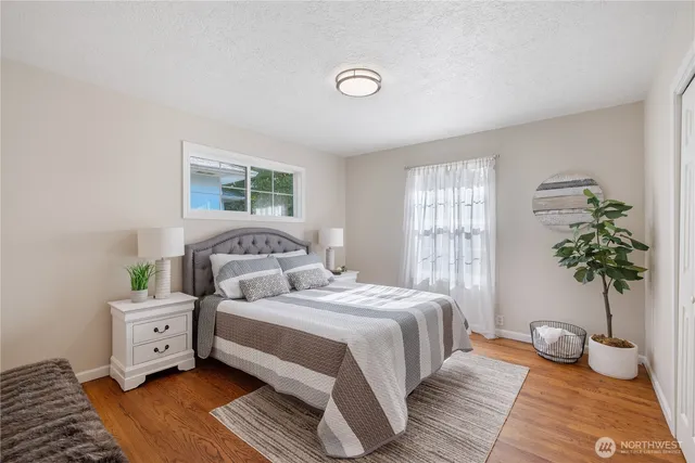 a bedroom with a bed and wooden floor