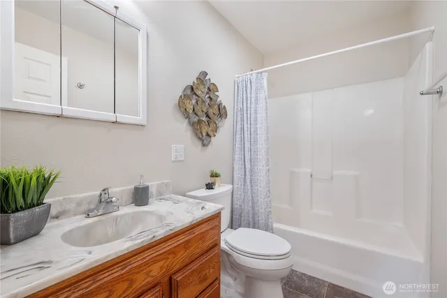 a bathroom with a granite countertop sink a toilet and bathtub