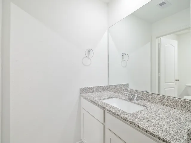 a bathroom with a granite countertop sink and vanity