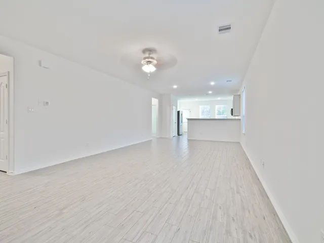 a view of a big room with wooden floor and windows