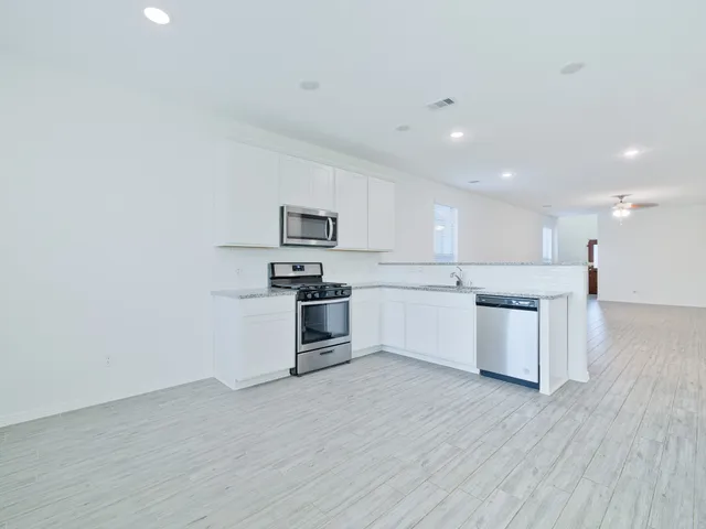 a kitchen with a refrigerator and a stove top oven