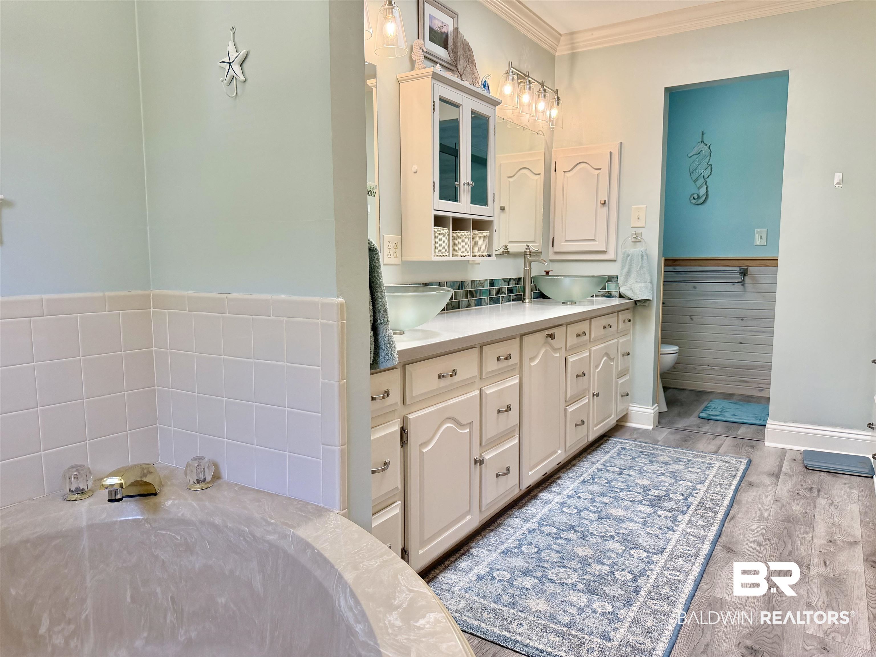 2944 Appleton Road Brewton, AL 36426 - Photo 20 of 65 Bathroom featuring double vanity, light wood-style flooring, crown molding, and a bath