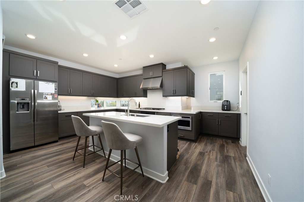 430 Transport Tustin, CA 92782 - Photo 2 of 37 a large kitchen with a center island wooden floor stainless steel appliances and cabinets