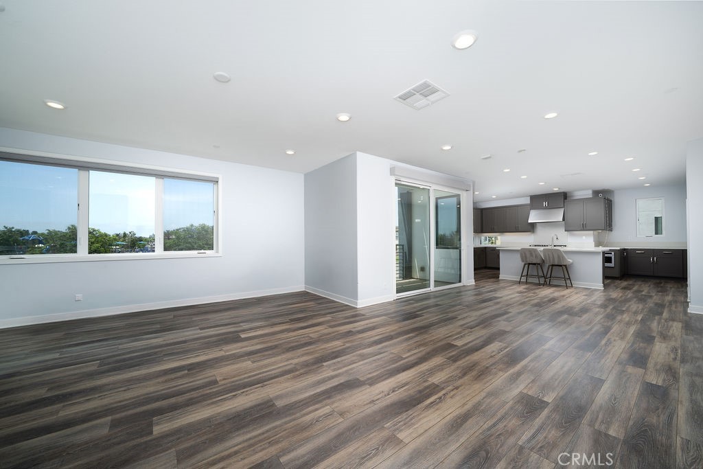 430 Transport Tustin, CA 92782 - Photo 22 of 37 a view of an empty room with wooden floor and a kitchen