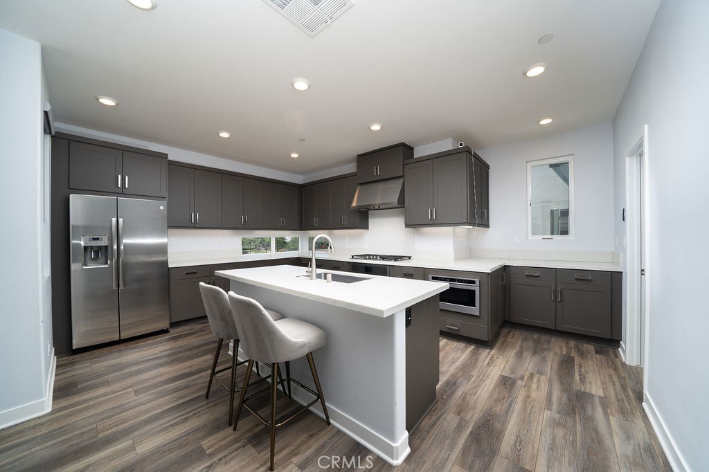 430 Transport Tustin, CA 92782 - Photo 24 of 37 a kitchen with stainless steel appliances granite countertop a sink a stove a refrigerator and island with wooden floor