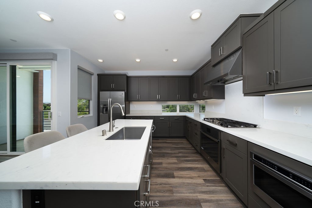 430 Transport Tustin, CA 92782 - Photo 25 of 37 a large kitchen with stainless steel appliances kitchen island a stove a sink dishwasher and a refrigerator with wooden floor