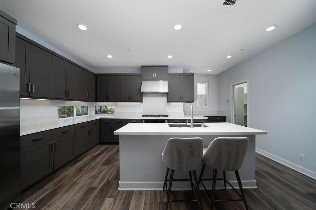 430 Transport Tustin, CA 92782 - Photo 26 of 37 a kitchen with stainless steel appliances granite countertop a table chairs sink refrigerator and cabinets