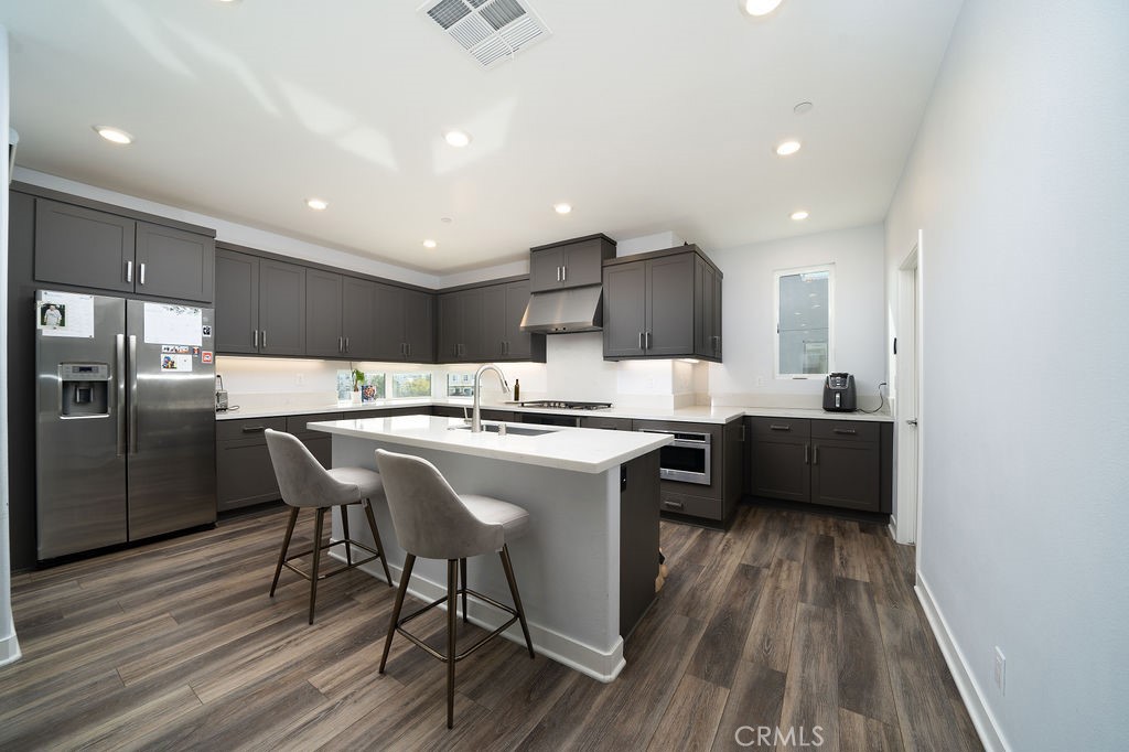 430 Transport Tustin, CA 92782 - Photo 32 of 37 a kitchen with stainless steel appliances granite countertop a sink a stove a refrigerator and island with wooden floor