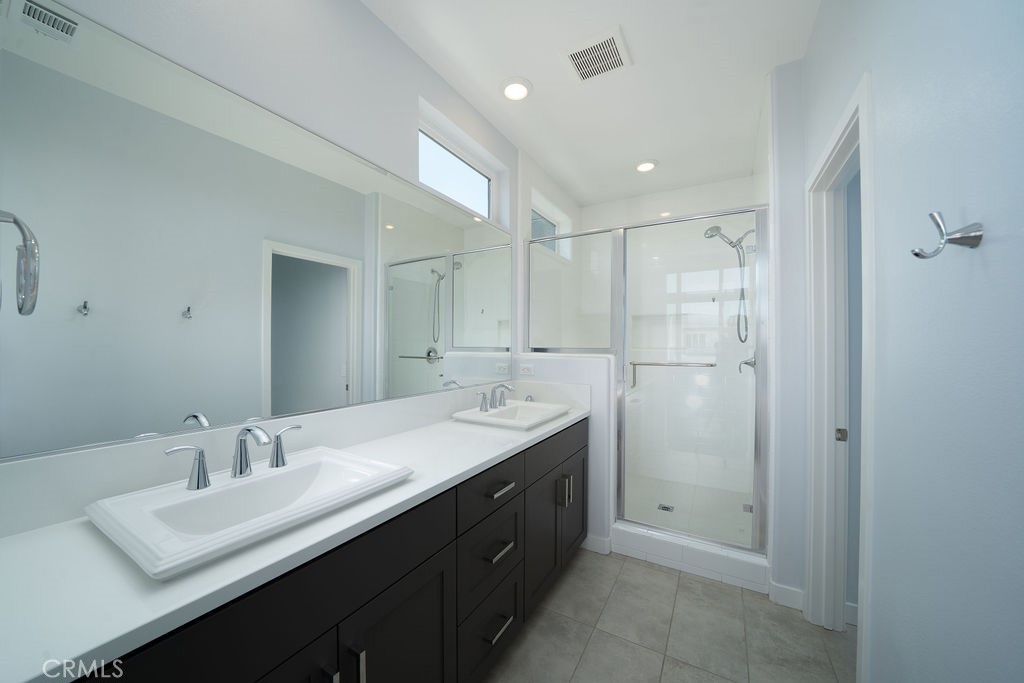 430 Transport Tustin, CA 92782 - Photo 6 of 37 a bathroom with a double vanity sink a mirror and a shower