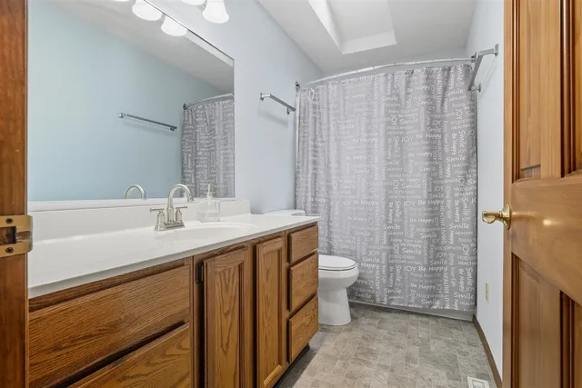 a bathroom with a sink a toilet and shower curtain