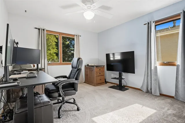 a view of a workspace with furniture and a window