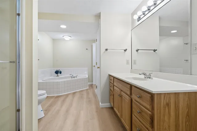 a bathroom with a tub sink and mirror