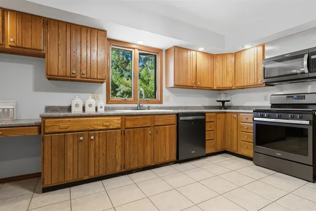 a kitchen with stainless steel appliances granite countertop a stove sink and cabinets