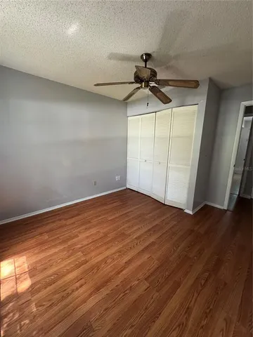 a view of a room with wooden floor and ceiling fan