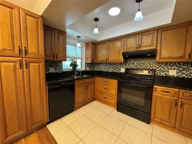 a kitchen with granite countertop a sink stainless steel appliances and cabinets
