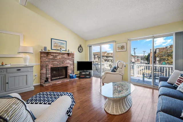 a living room with furniture a fireplace and a large window