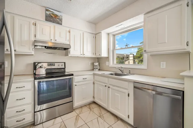 a kitchen with white cabinets and white appliances