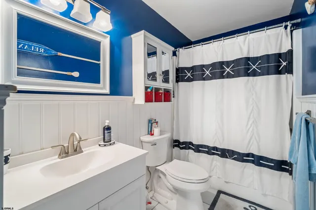 a bathroom with a sink a toilet and a shower curtain