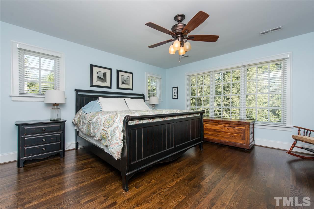 2218 Creston Road Raleigh, NC 27608 - Photo 14 of 25 a bedroom with a bed and a chandelier