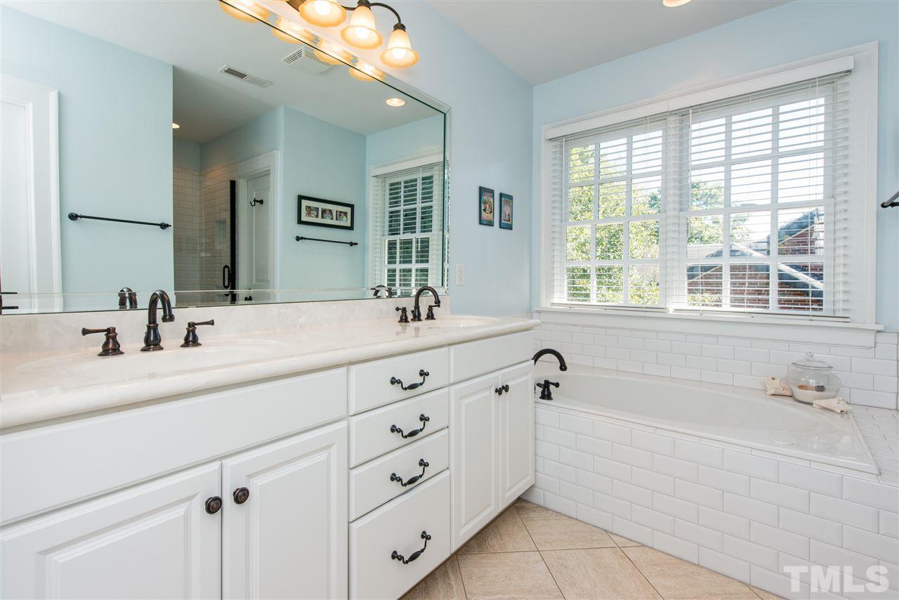 2218 Creston Road Raleigh, NC 27608 - Photo 15 of 25 a bathroom with double vanity sink a mirror a window and vanity