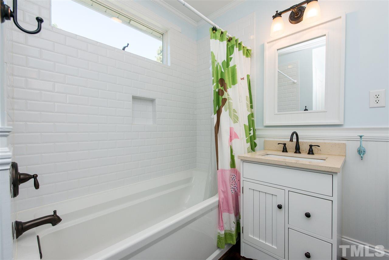 2218 Creston Road Raleigh, NC 27608 - Photo 18 of 25 a bathroom with a granite countertop sink a vanity and a mirror