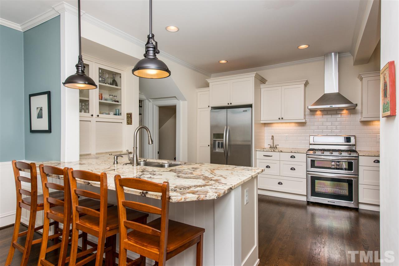 2218 Creston Road Raleigh, NC 27608 - Photo 7 of 25 a kitchen with stainless steel appliances kitchen island granite countertop a stove a refrigerator and wooden floor
