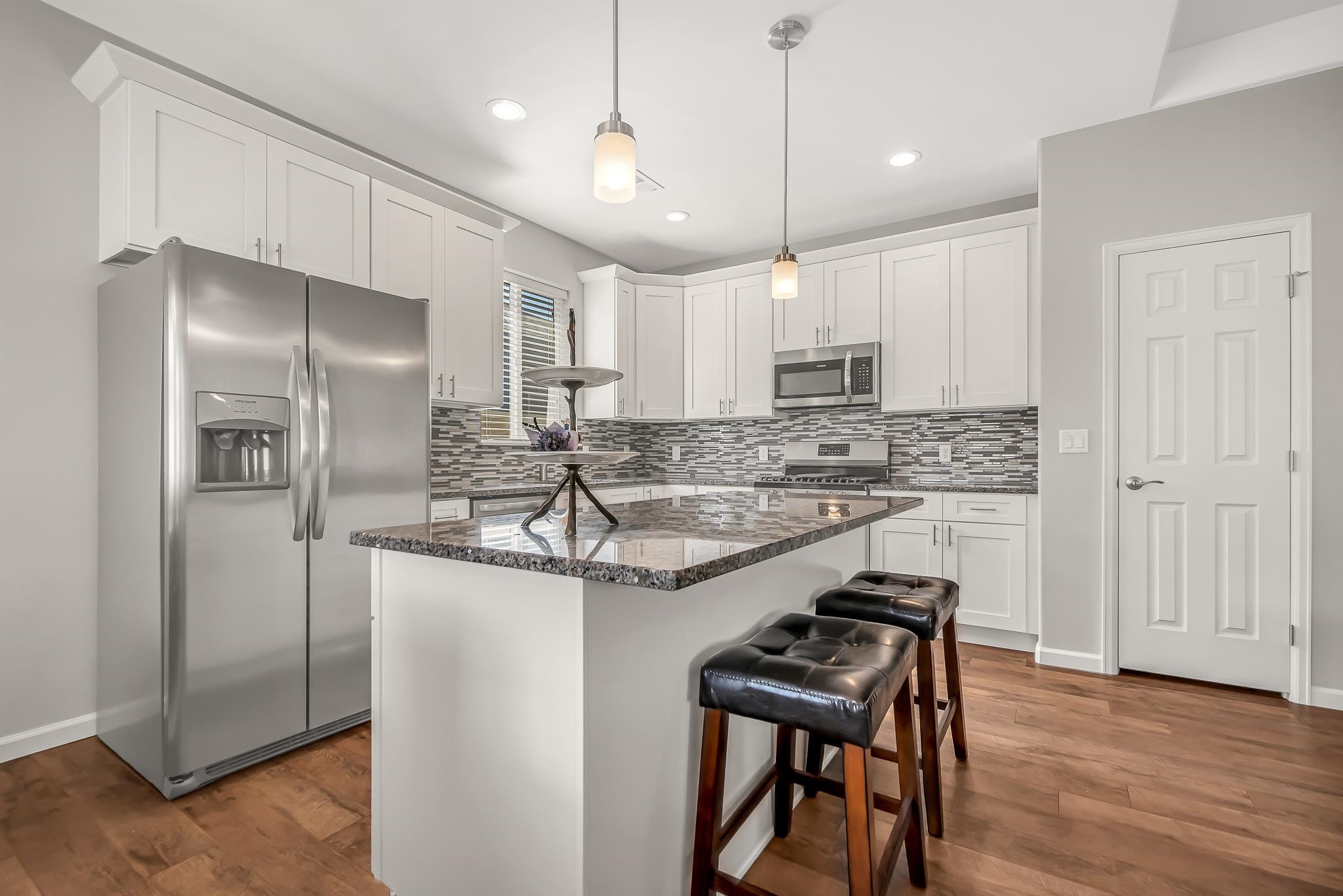 454 Lewis Street Grand Junction, CO 81504 - Photo 8 of 25 a kitchen with kitchen island granite countertop stainless steel appliances lots of counter top space cabinets and wooden floor