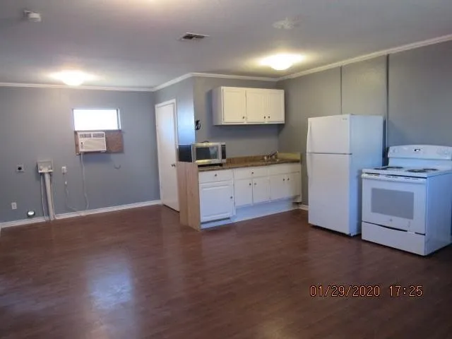 a kitchen with granite countertop white cabinets and white appliances
