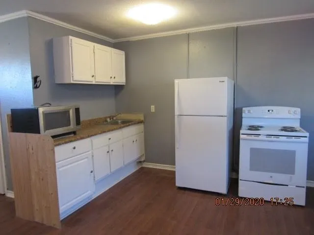 a kitchen with a refrigerator sink stove and cabinets
