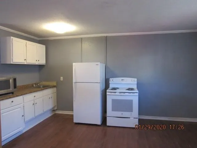 a kitchen with a stove a refrigerator a sink and dishwasher with white cabinets