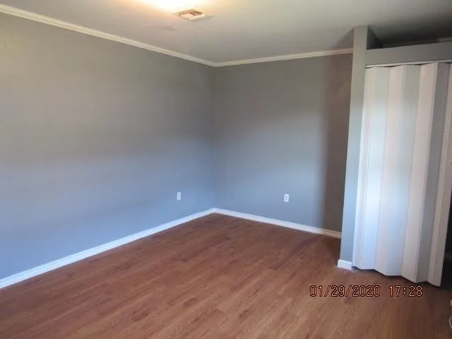a view of an empty room with wooden floor