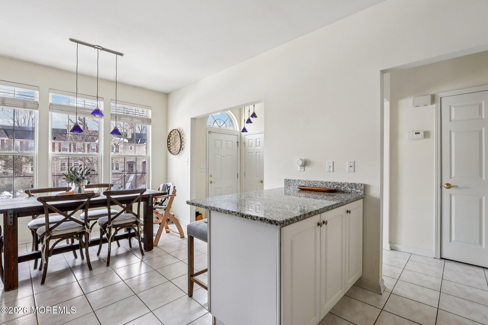 14 West Aspen Way Matawan, NJ 07747 - Photo 11 of 46 a kitchen with stainless steel appliances granite countertop a stove a refrigerator a dining table and chairs with the cabinets