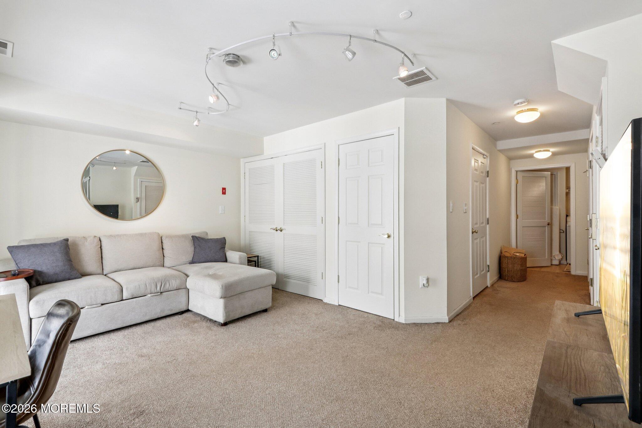 14 West Aspen Way Matawan, NJ 07747 - Photo 21 of 46 a living room with furniture a mirror and a chandelier