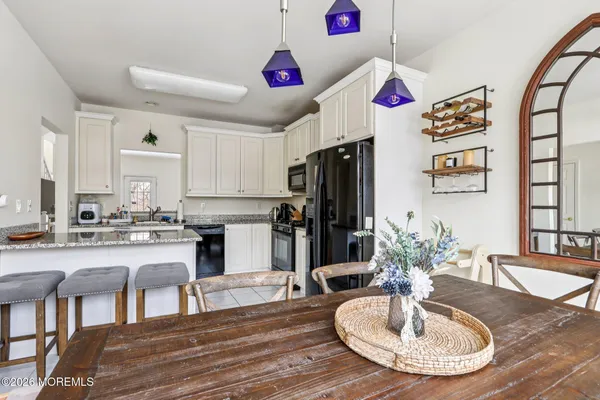 a kitchen with sink refrigerator dining table and chairs