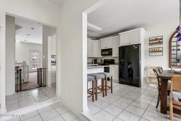a kitchen with stainless steel appliances granite countertop a stove a refrigerator a dining table and chairs with the cabinets