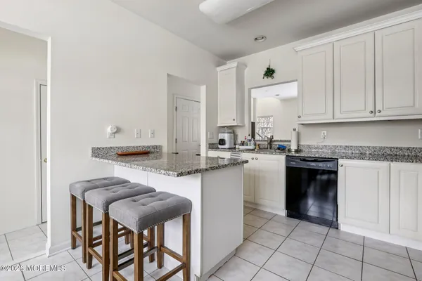 a kitchen with a refrigerator sink and white cabinets