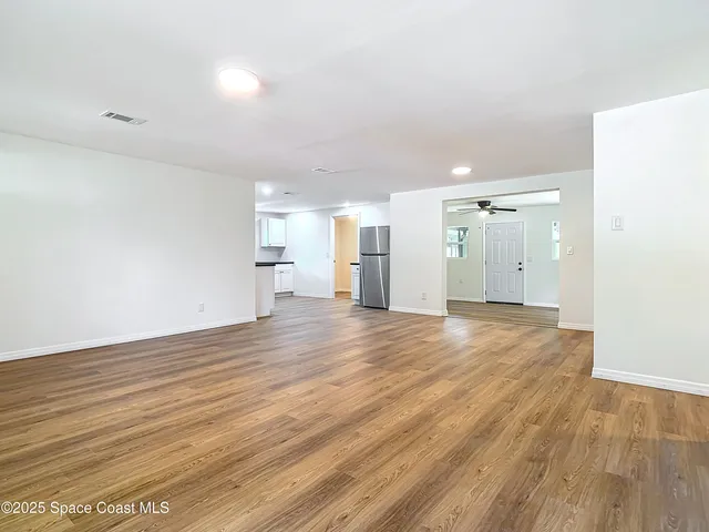 a view of empty room with wooden floor