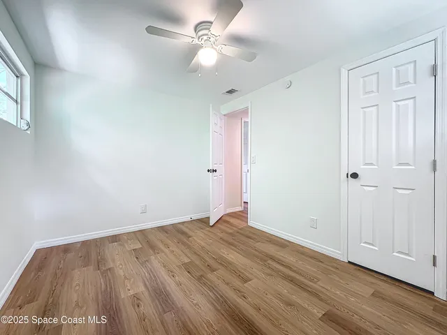 a view of an empty room with wooden floor