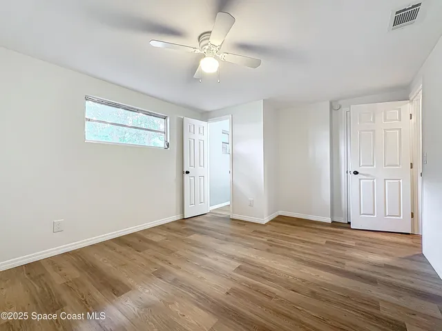 a view of an empty room with wooden floor