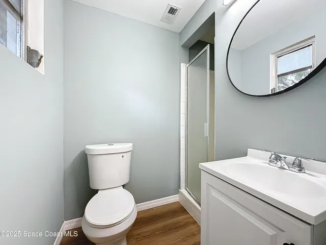 a white toilet sitting next to a bathroom sink and a mirror