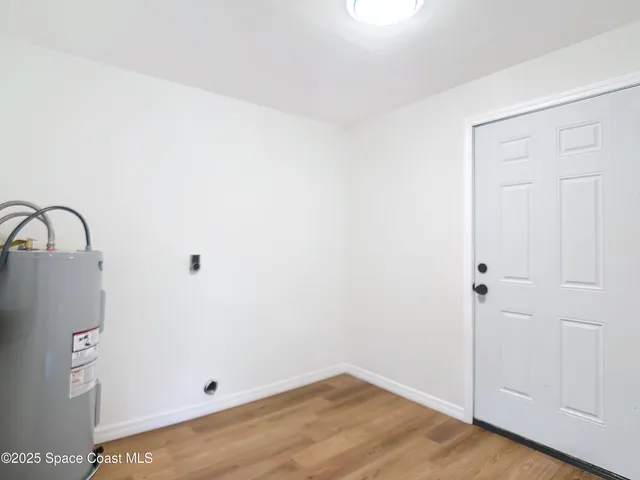 a view of a small space with wooden floor and a sink