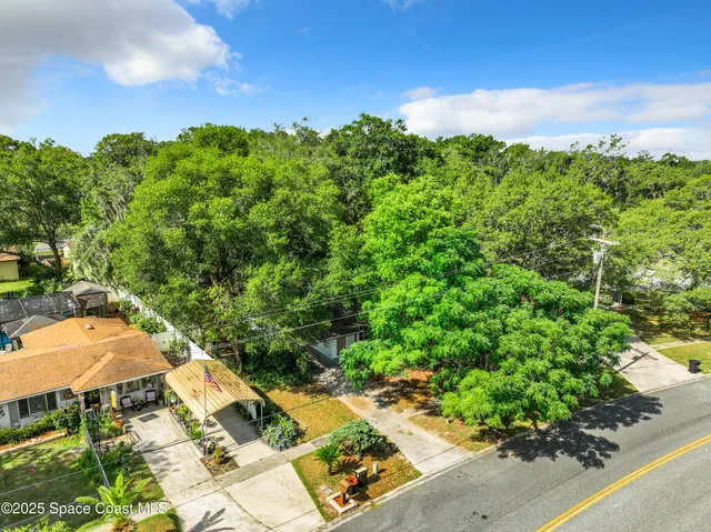 an aerial view of a residential houses with yard and outdoor seating