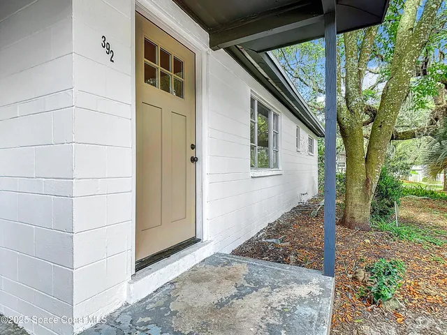 a view of a house with backyard and trees